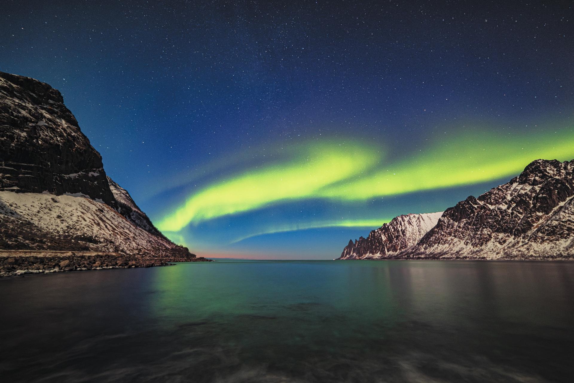 Aurora boreal entre mar y montañas