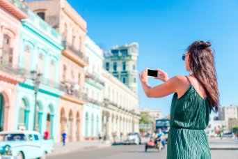 Mujer fotografiando edificios en La Habana vieja