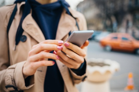 viajera de kannay sosteniendo móvil mientras usa la app del viajero