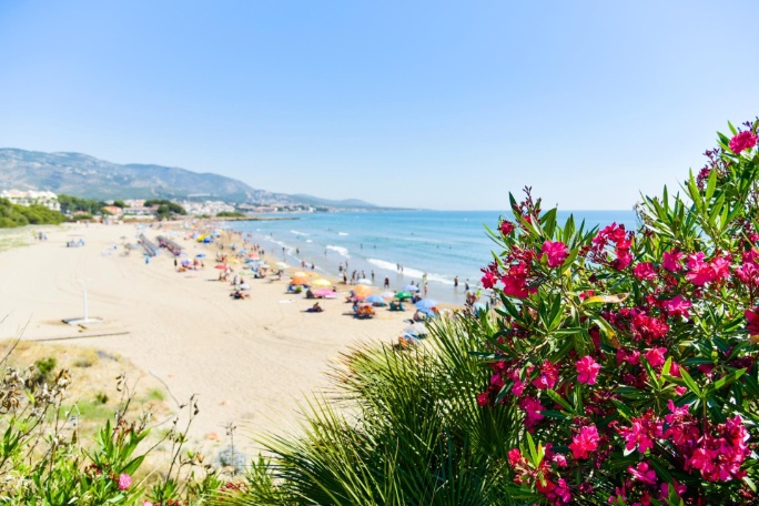 vistas a la playa de Romana en Alcossebre, en la Costa del Azahar, España, con gente irreconocible disfrutando del calor