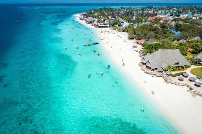  Vista aérea de playa Nungwi, en Zanzíbar, con arena blanca, aguas turquesas, barcas y resorts junto a la costa
