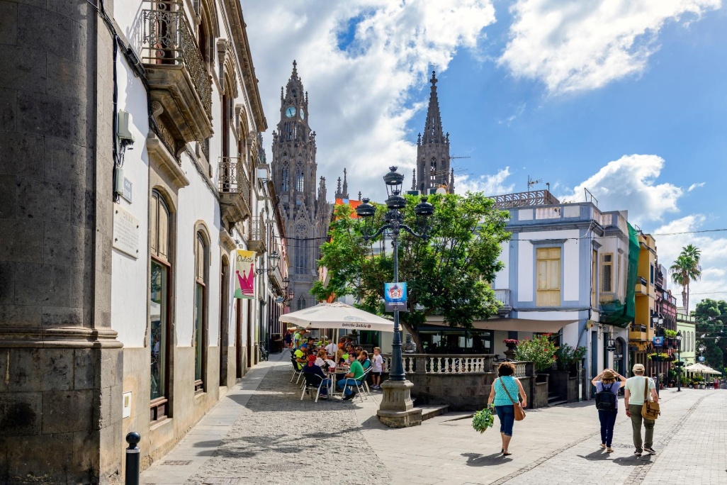 Paseantes en Arucas Gran Canaria con Parroquia de San Juan Bautista de Arucas de fondo