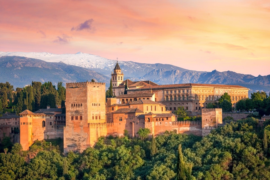 vista del alhambra al atardecer en granada con sierra nevada de fondo