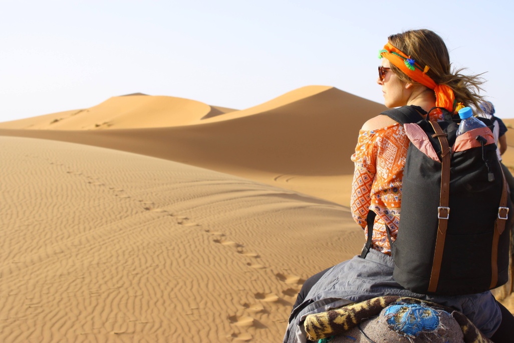 Mujer sobre camello paseando por el desierto del Sáhara