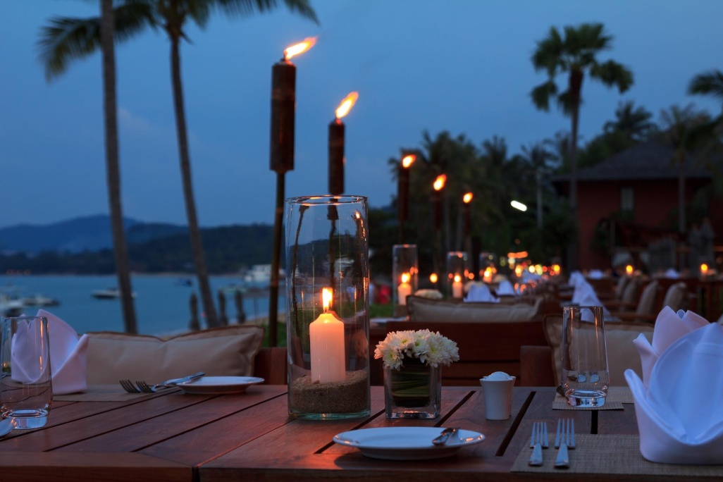 mesa preparada para cenar en terraza de restaurante junto a la playa