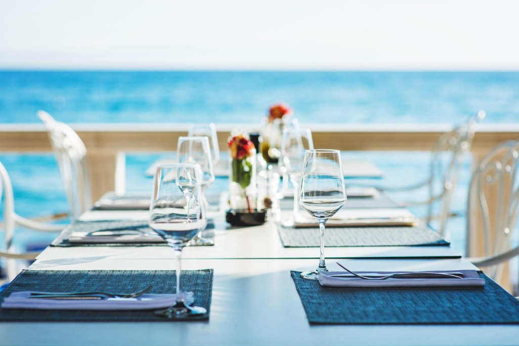 mesa preparada para comer en terraza de restaurante frente al mar