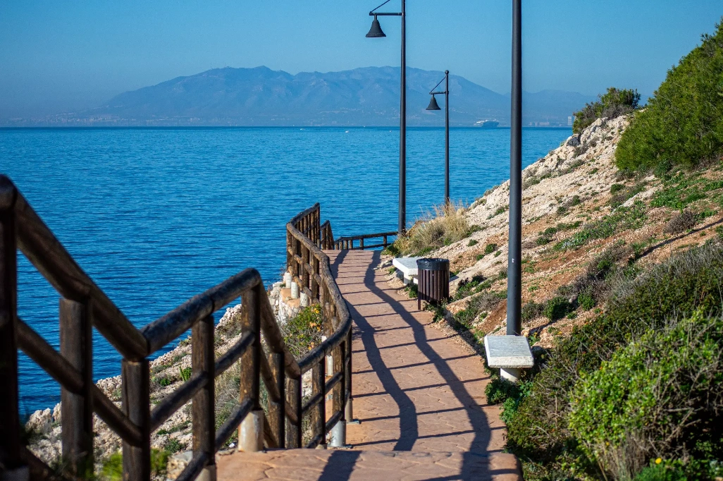 Sendero costero de Rincón de la Victoria, en Málaga, con vistas al mar Mediterráneo, farolas y ladera rocosa