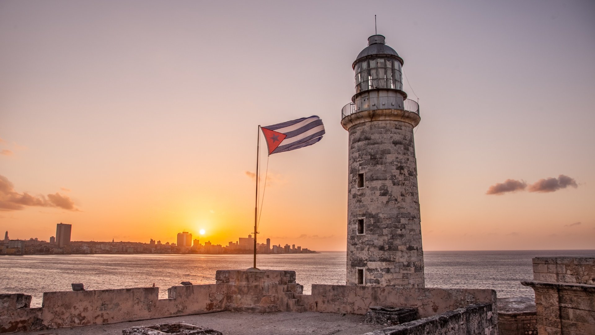 Bandera cubana junto al Faro del Castillo del Morro en La Habana