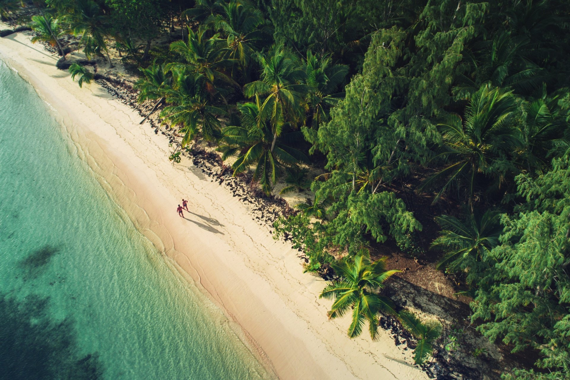 Vista aérea de una pareja paseando por la playa virgen en Punta Cana
