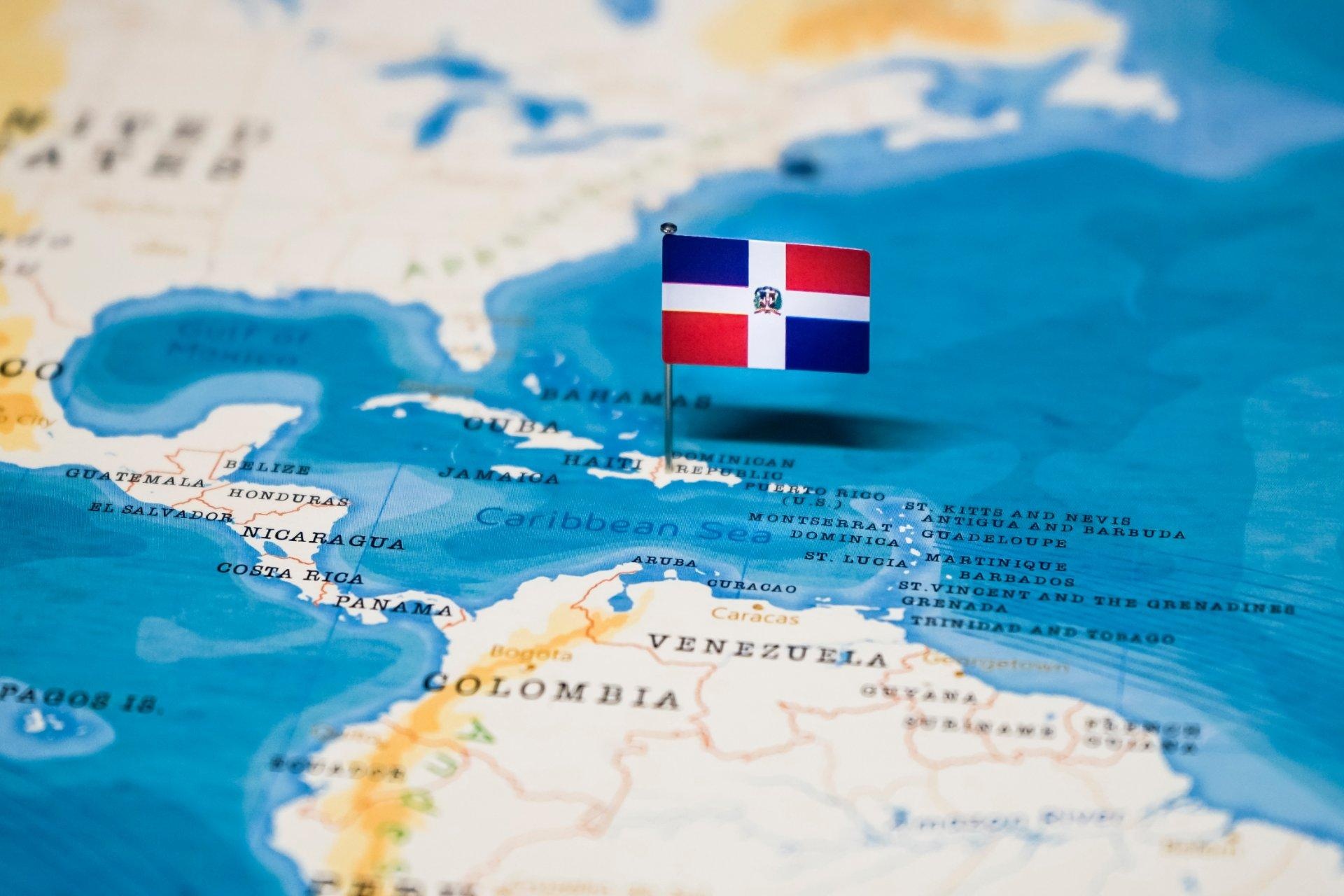 bandera de república dominicana clavada sobre el país en mapa del caribe
