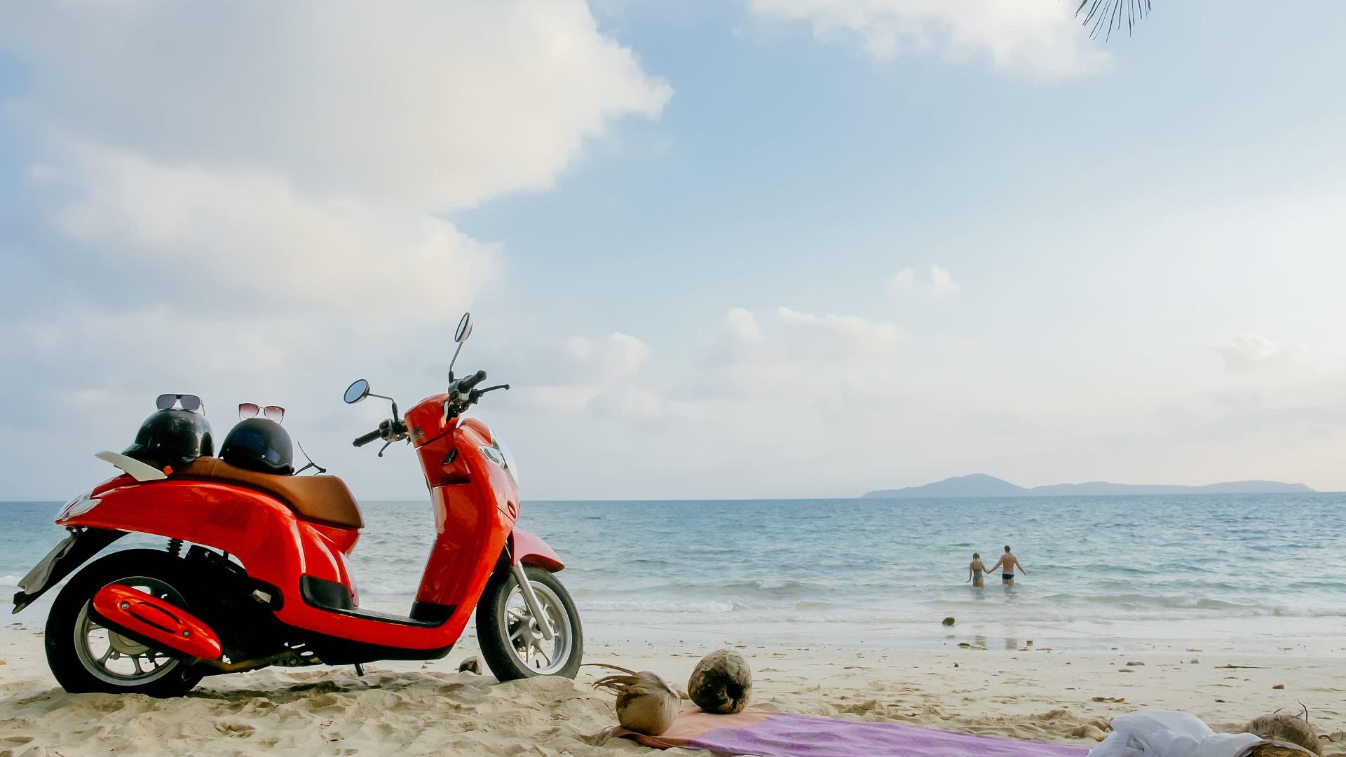Moto roja en una playa de ibiza
