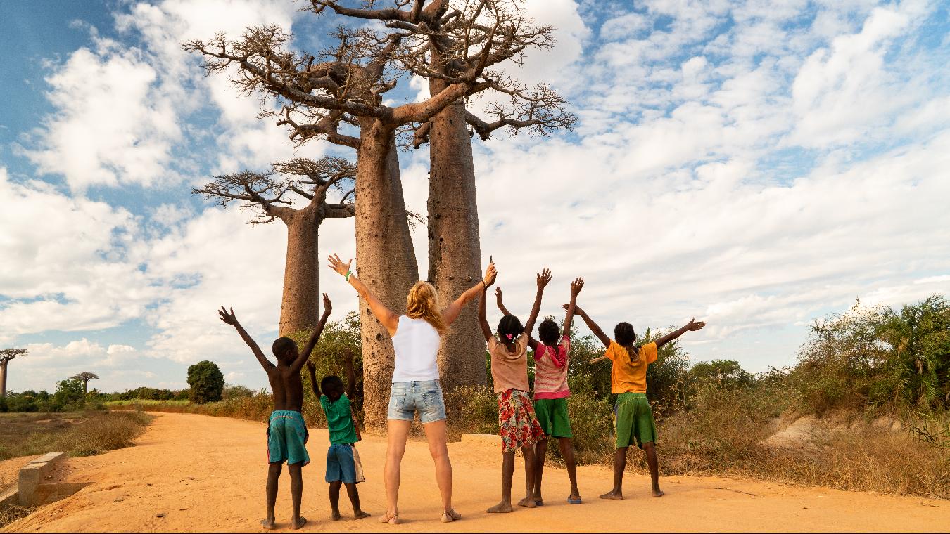 Mujer con niños africanos haciendo rito de unión