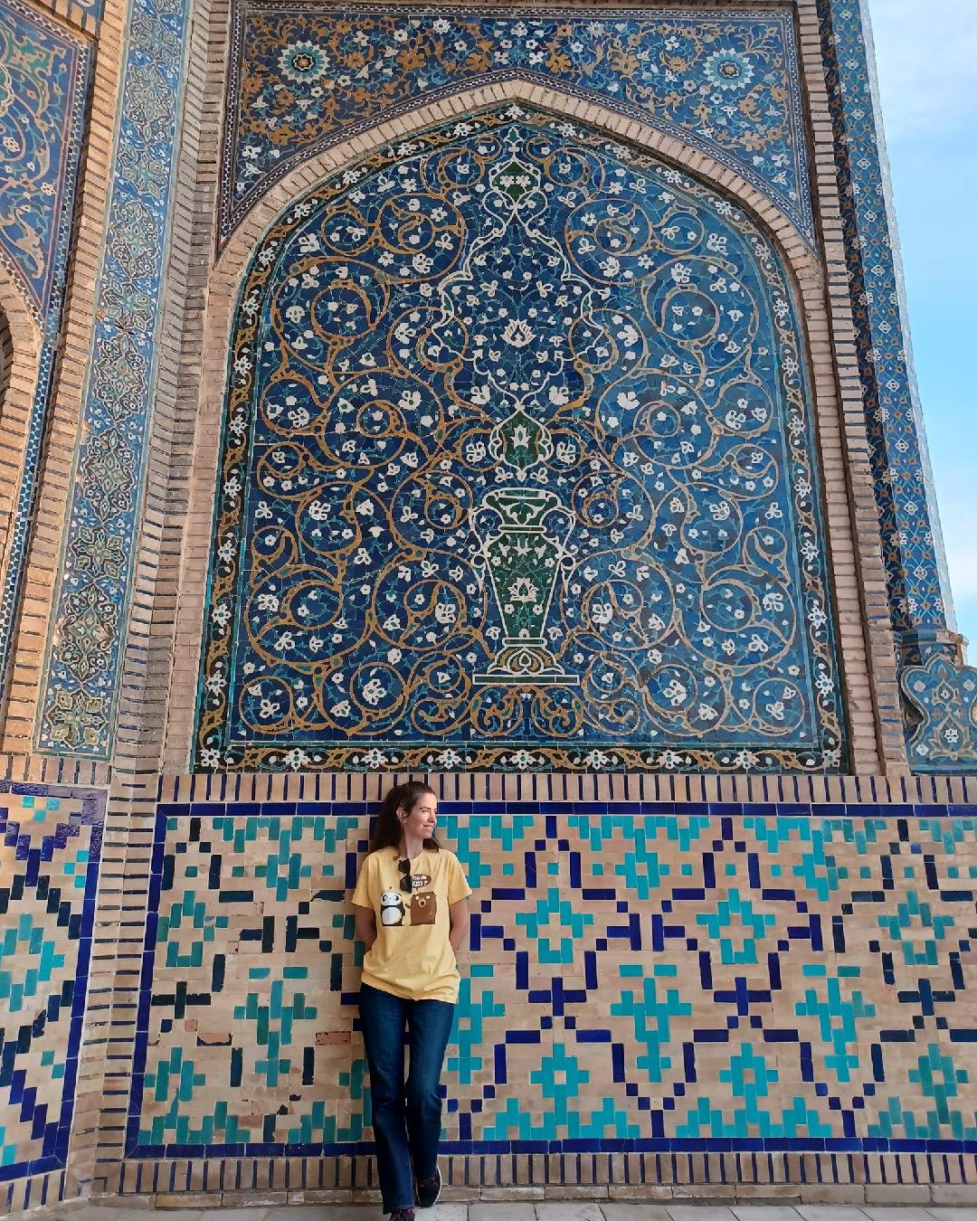 Lola apoyada en la pared de azulejos en Bukhara