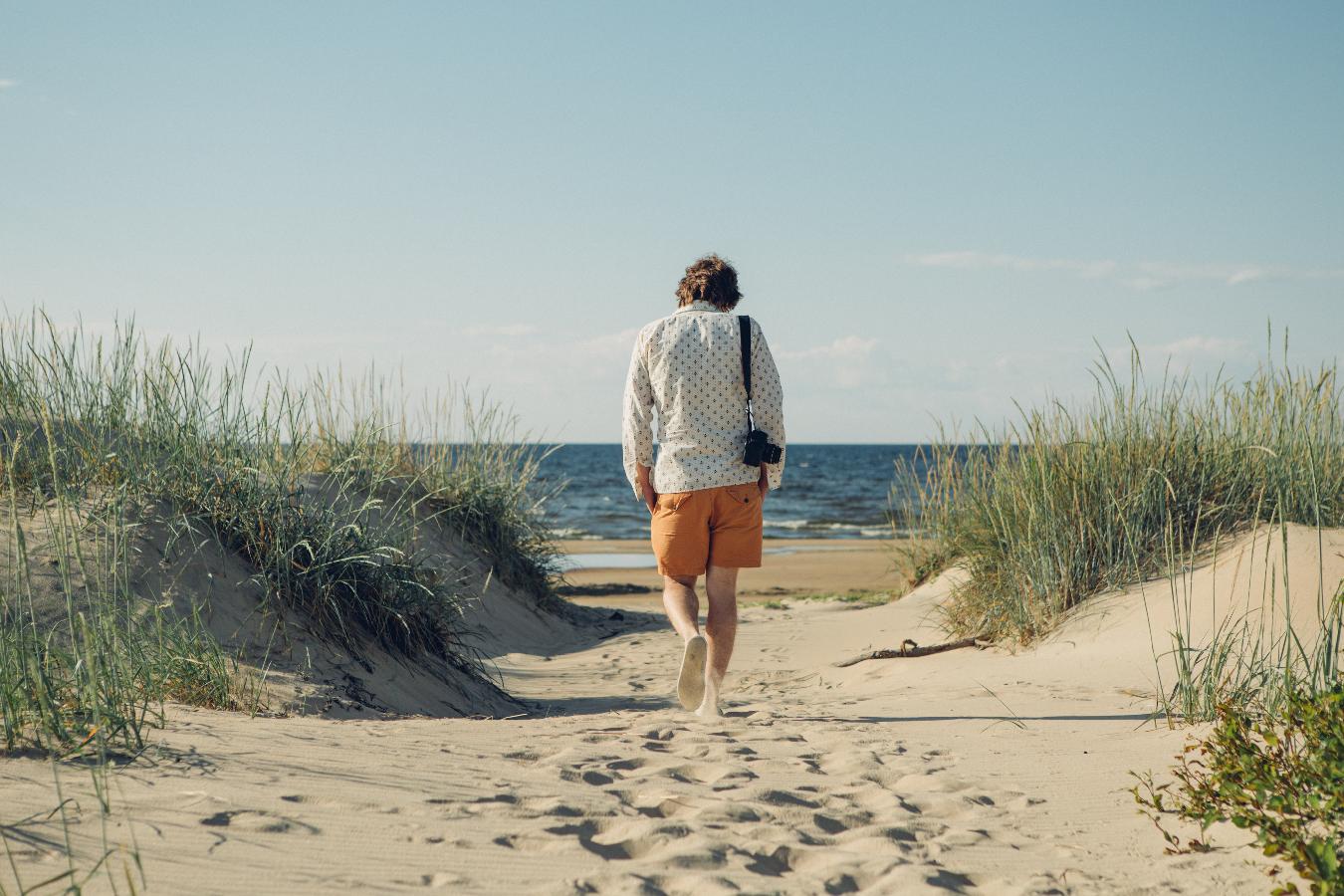 Hombre caminando descalzo por las dunas en la playa de Hailuoto