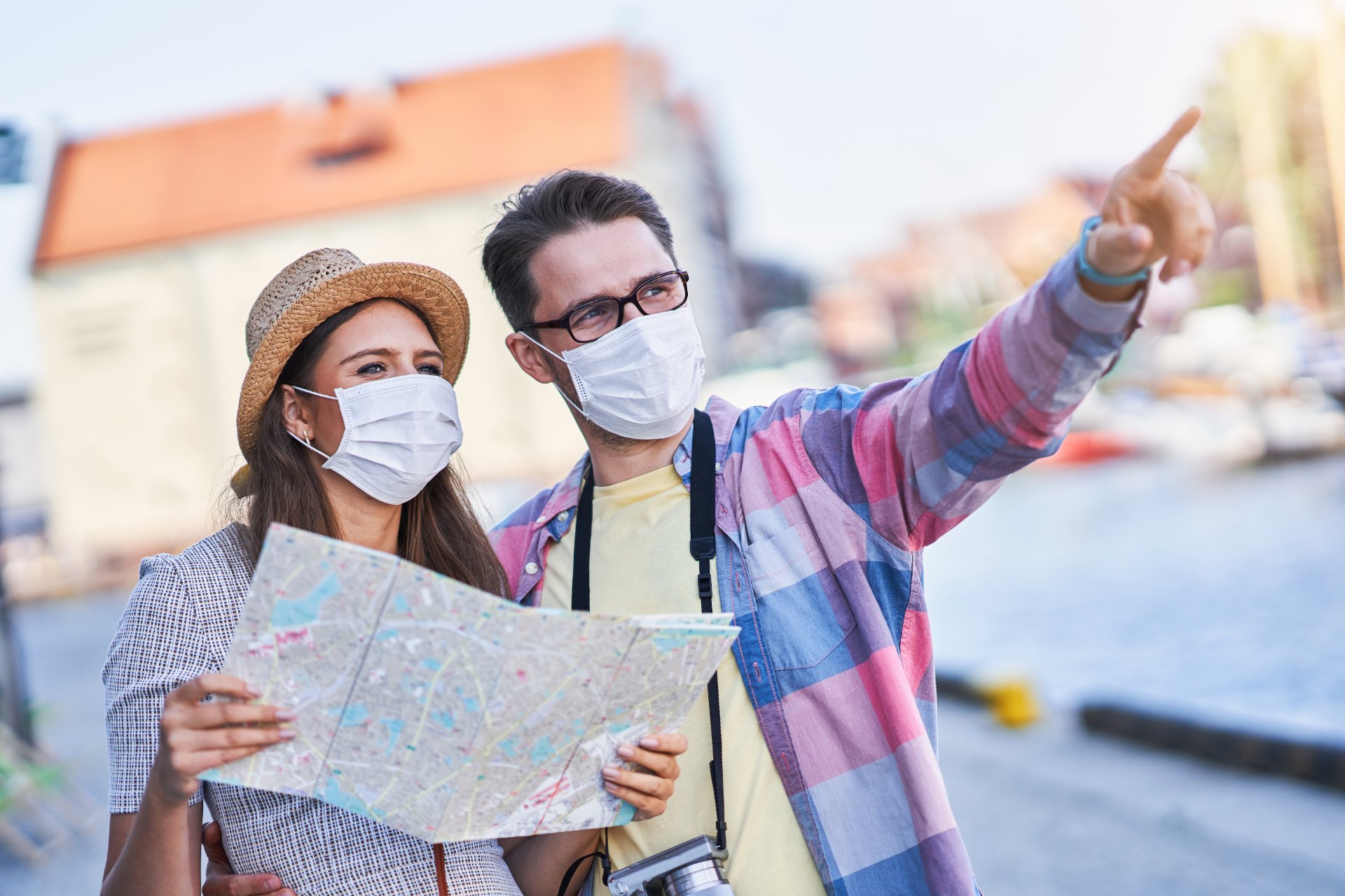 Turistas con mascarilla leyendo un mapa