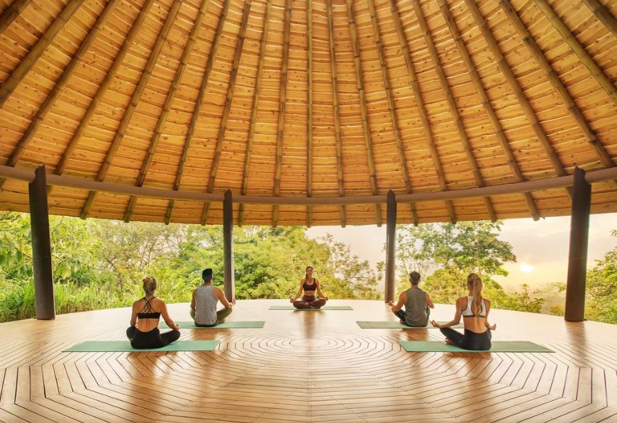 Grupo de viajeros practicando yoga al aire libre en Costa Rica